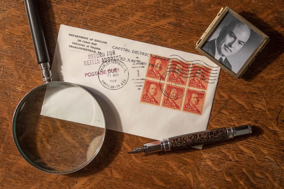 Magnifying glass, fountain pen, picture in a small square frame, and a letter