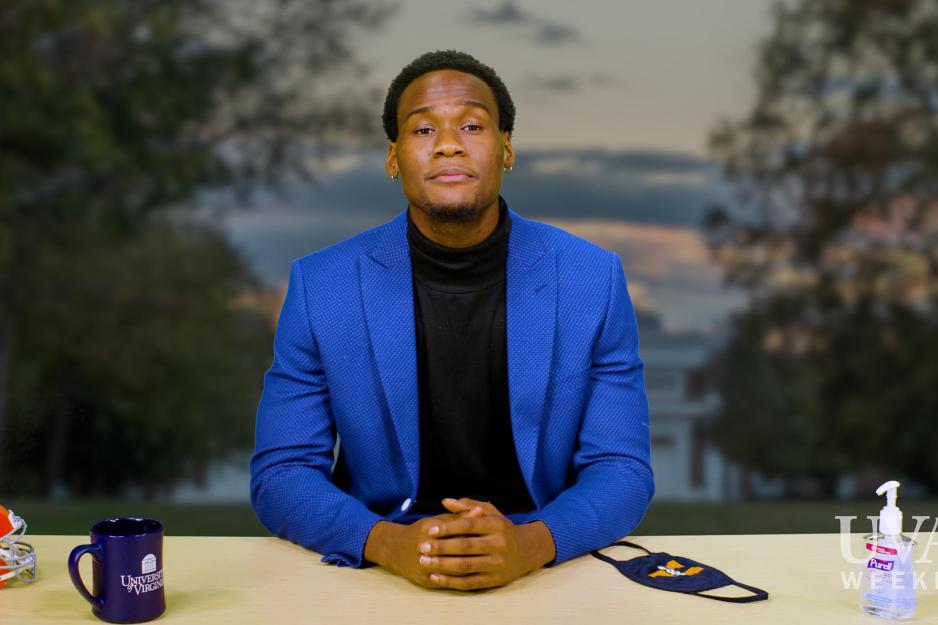 Student sitting at a reporter desk holding his own hands on table 