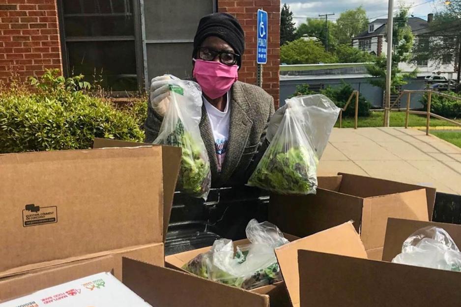 Rosa Key holding bags of lettuce 