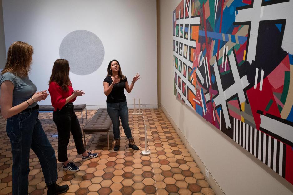 rankie Mananzan, speaks to two others about an abstract art piece