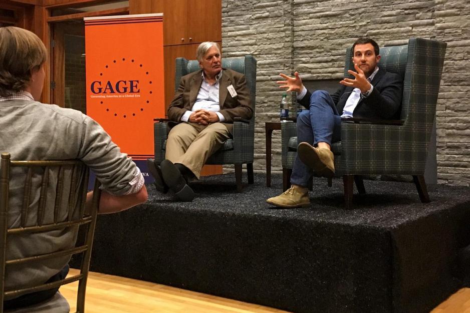 Dan Keyserling, right, sits on a stage talking to a crowd