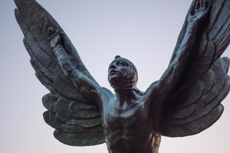Statue of a man with feathers strapped to his arms