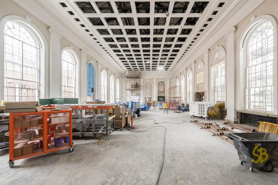 Room in Alderman Library with construction supplies on the ground and the ceiling panels out.