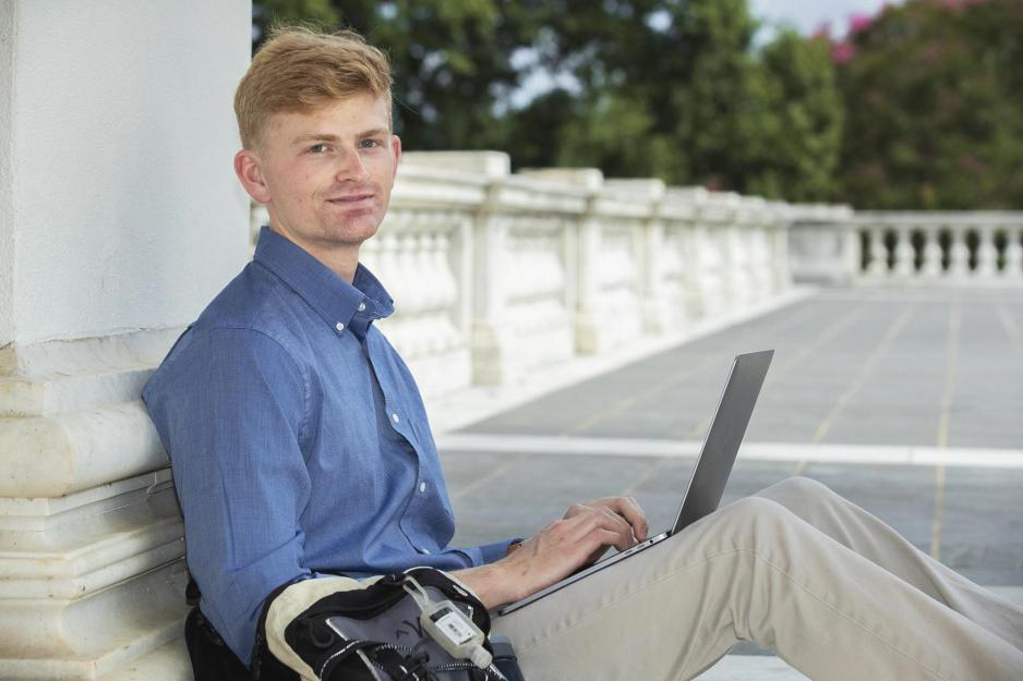 Avery Walters sitting on the ground of the Rotunda leaning against a Rotunda pillar