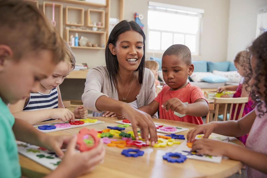 Teacher working with preschool aged children working on a craft