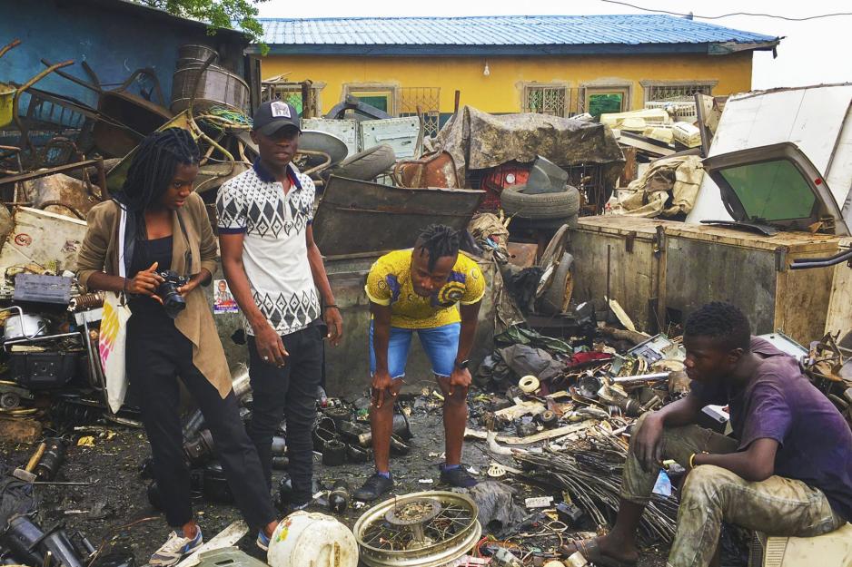 Kwame Otu (middle bent over) visiting a house in Ghana 
