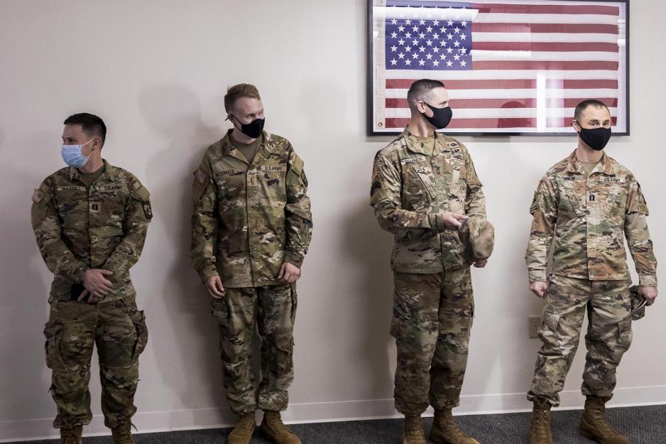 Army ROTC instructors lined up next to a wall