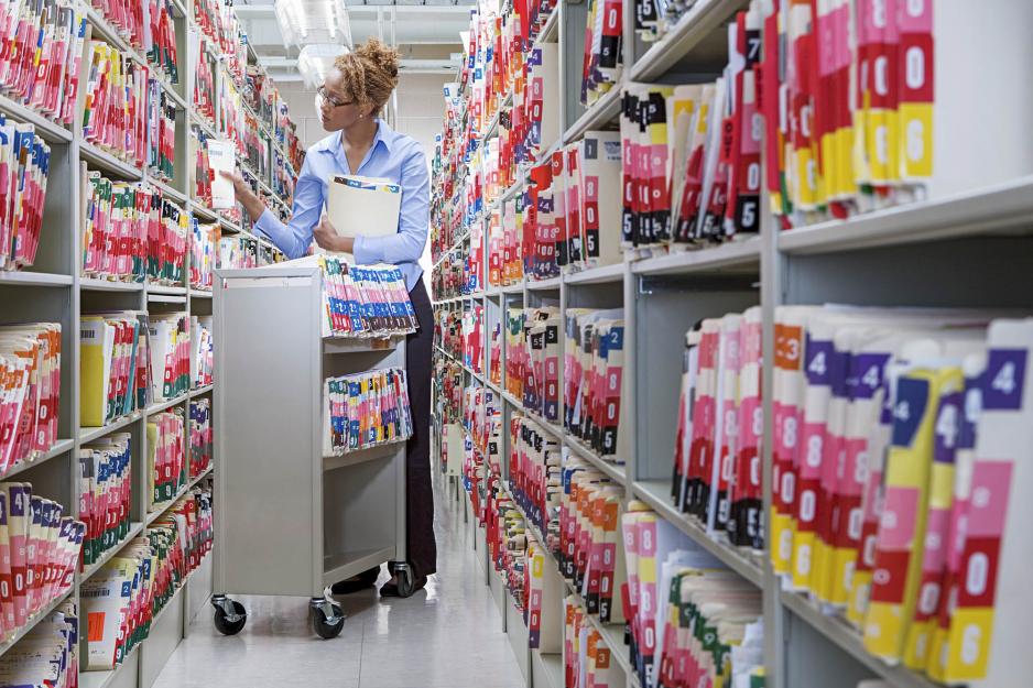 Woman with a cart filled with health files 