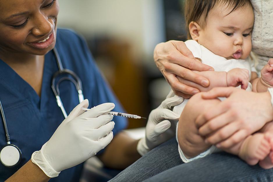 Healthcare professional giving a baby an injection