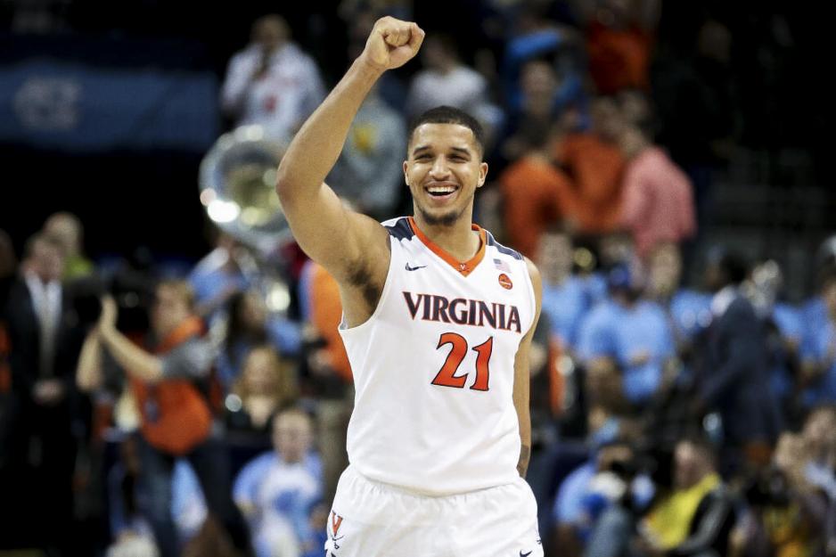 Isaiah Wilkins raising his right hand in the hand as he walks across the court with a huge smile