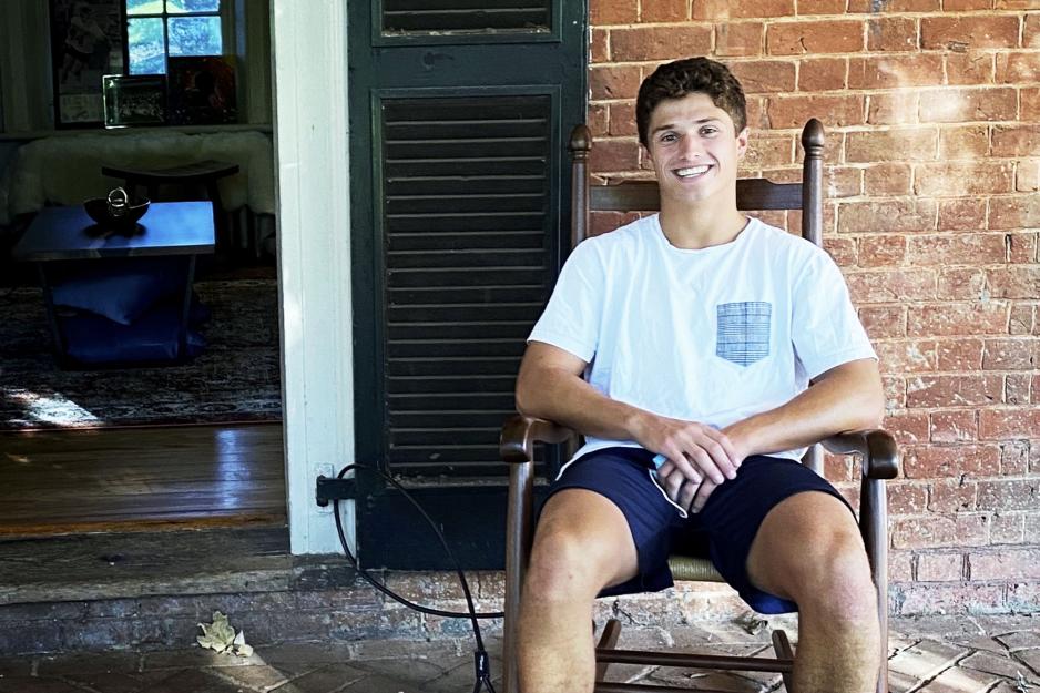 Jackson Appelt sitting in a rocking chair outside of his room on the Lawn