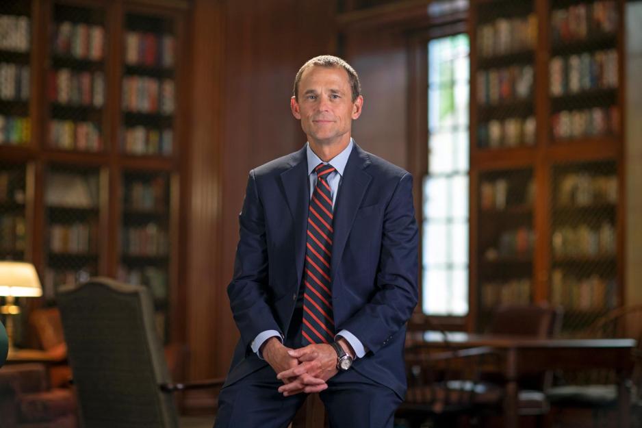 Jim Ryan sits on a table facing the camera