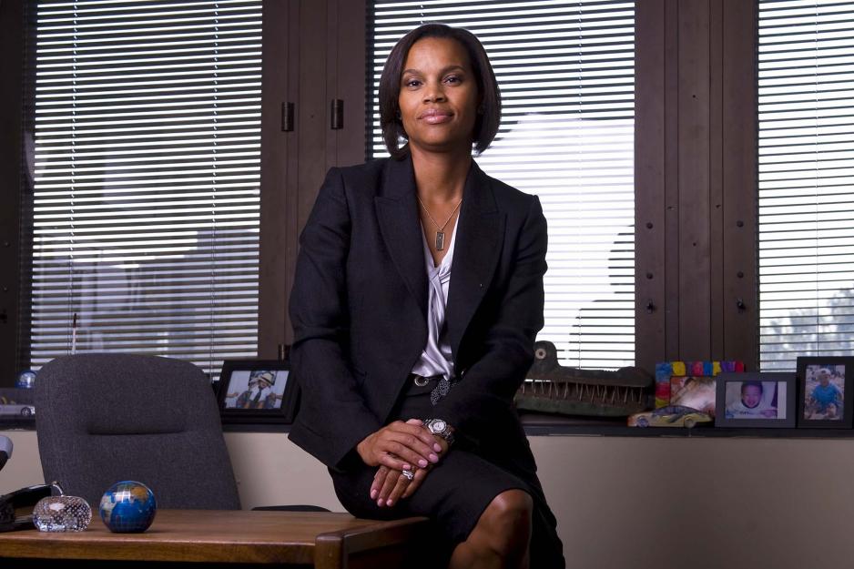 Karla Smith sitting on the edge of her desk looking at the camera