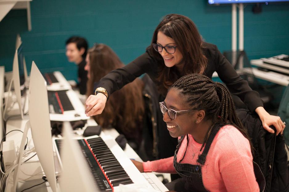 Mona Kasra works with a student on a computer