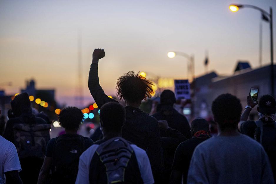 Group of people protesting in the streets at dusk