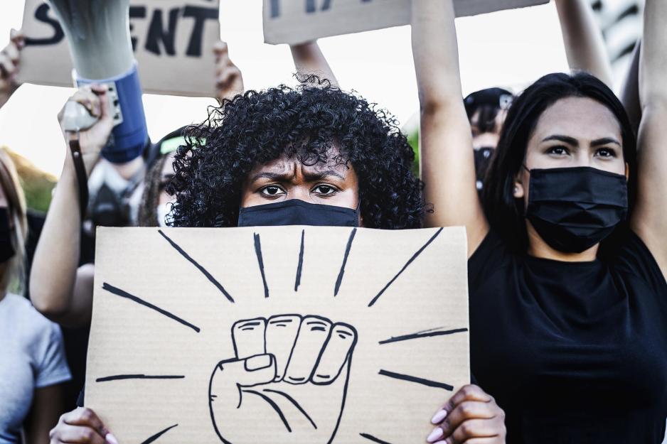 Women protesting holding signs made out of cardboard