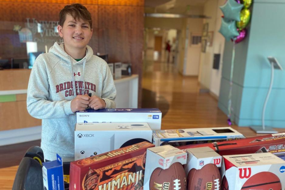 Luke Post standing at a table in the Children's hospital that has various games on it