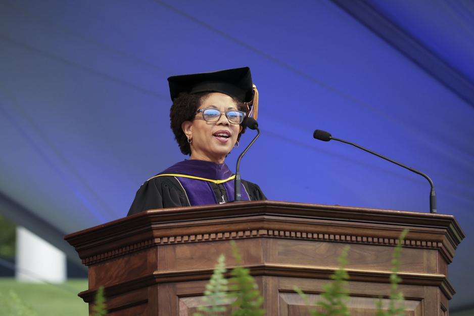 Melody Barnes standing at the podium giving a speech at graduation