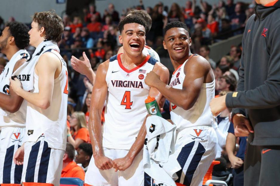 Justin McKoy (4) and Casey Morsell laugh on the side of the basketball court