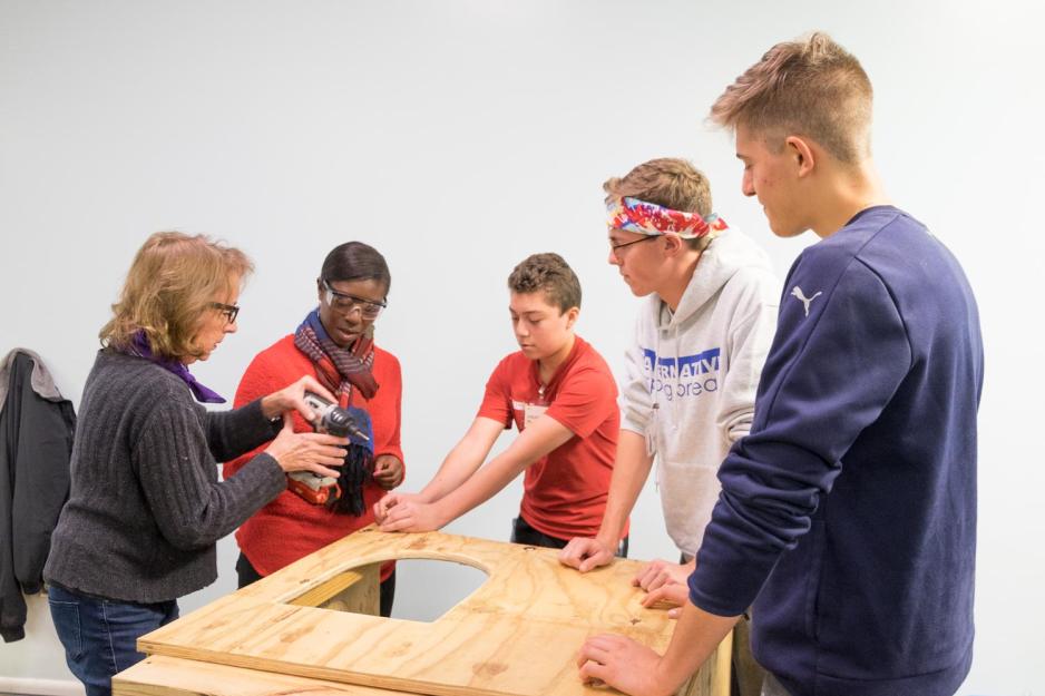Chris Sausa, right, Johan, center,  Garrett Lukens, Sharon Shafer (left),and  Moriah Davis work on building a doghouse together