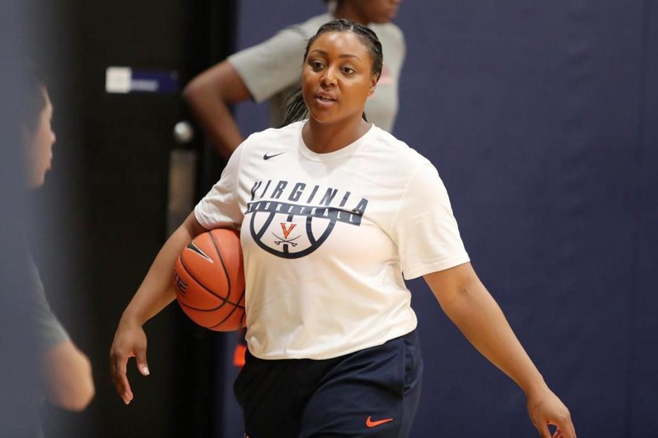 Monica Wright holding a basketball talking to players