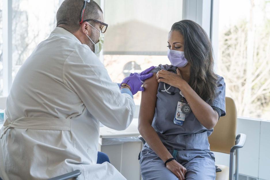 Dr. Ebony Hilton receiving a  vaccine by Justin Vesser
