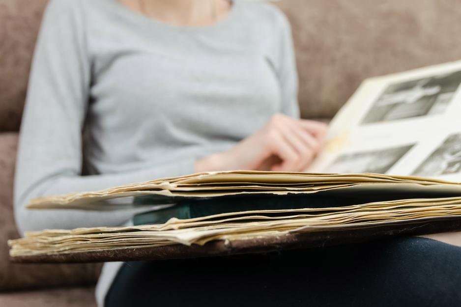 Person looking at a tattered photo album 