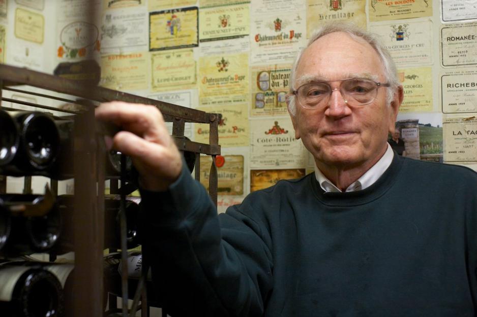 Paul Gaston standing next to a wine rack