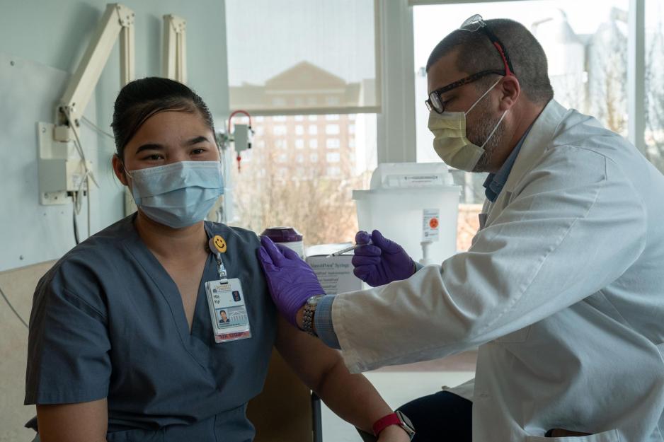Hla Kyi, getting vaccinated by a fellow UVA Health Employee