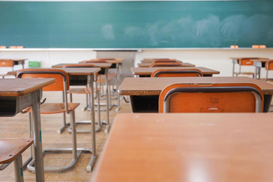 Empty Classroom chairs and desks and empty green blackboard
