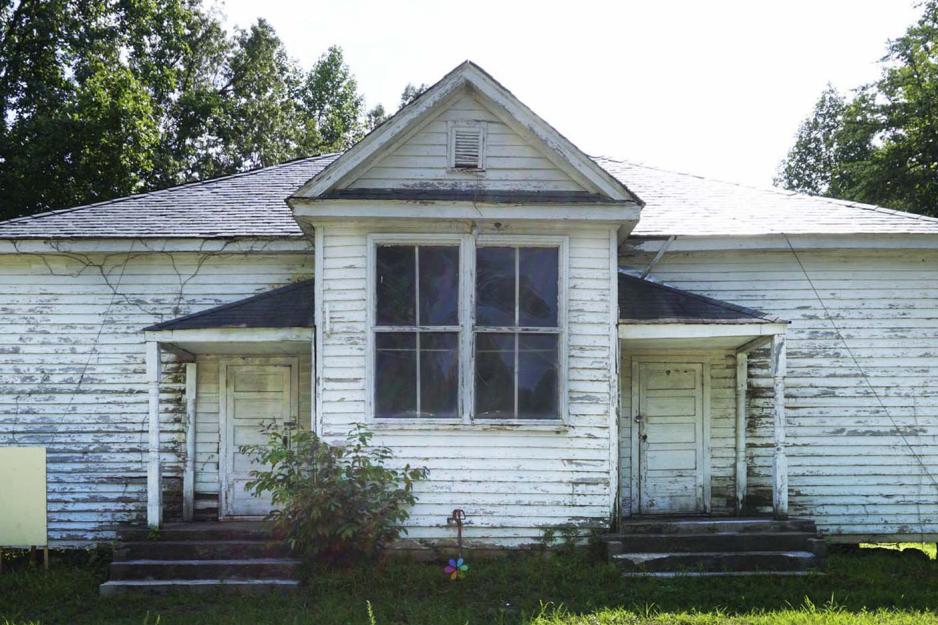 Outside of the Pine Grove Elementary School with chipped white paint and warn down wood