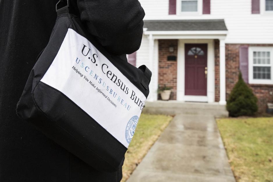 An enumerator walking up to a house