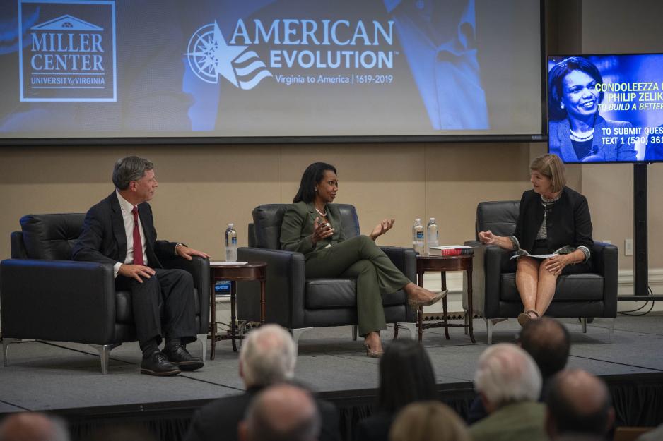 Philip Zelikow, left, Condoleezza Rice, center, and Ann Compton sit in chairs on a stage talking to a crowd