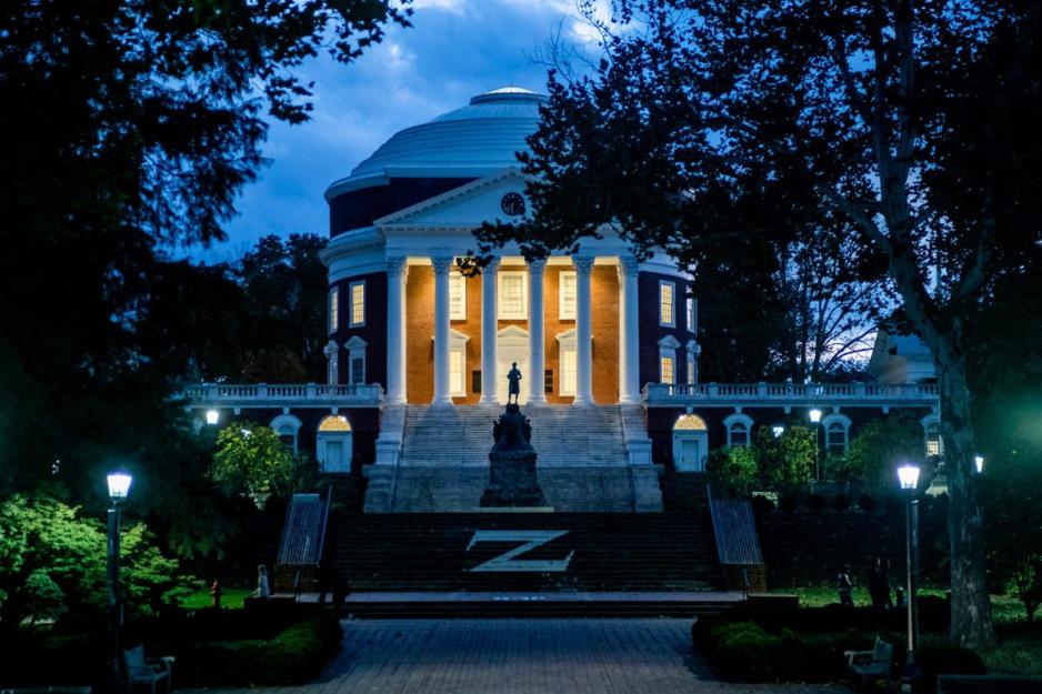 Rotunda at night with the porch lights on highlighting the white columns