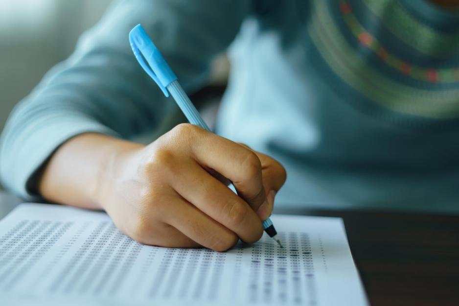 Student with a pencil filling in a scantron document