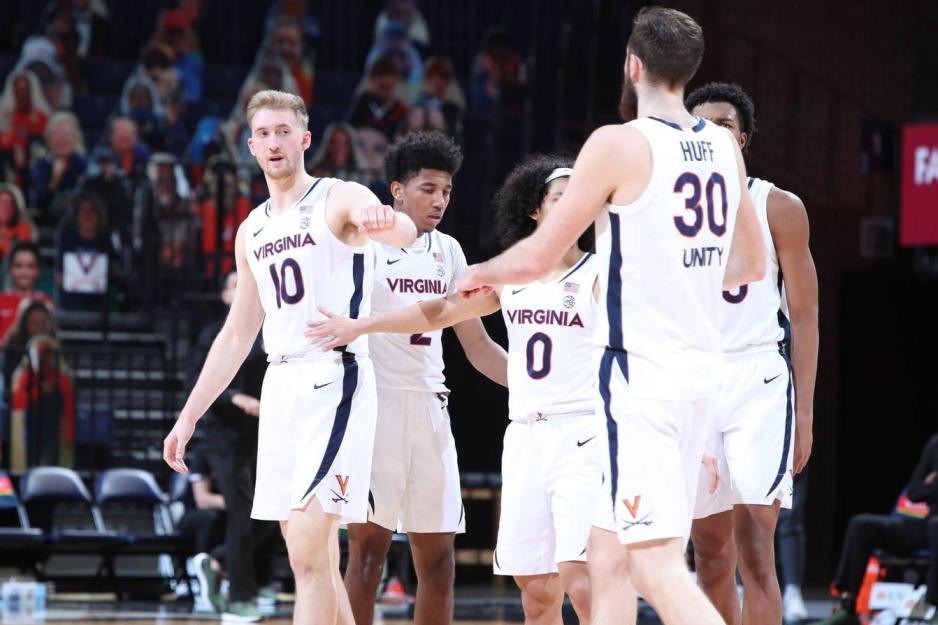 UVA mens basketball teammates giving each other low fives on the court