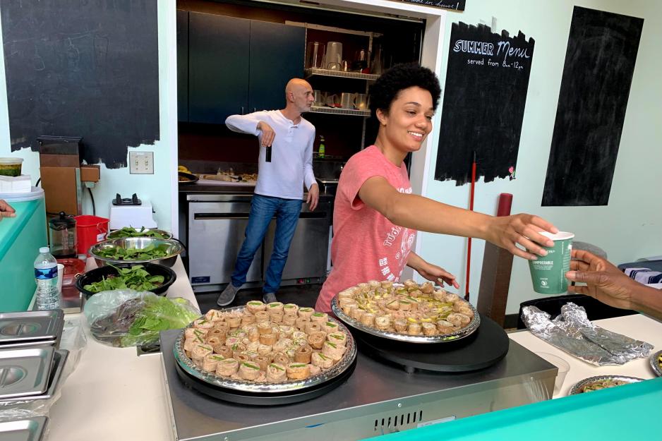 Woman serves coffee to a customer