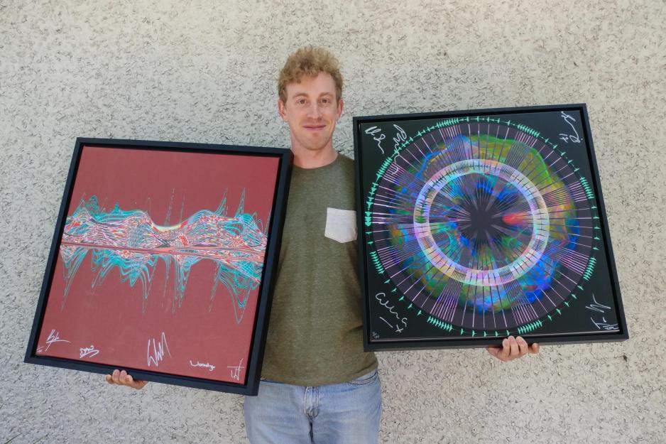Jeremy Klitzman holds two paintings