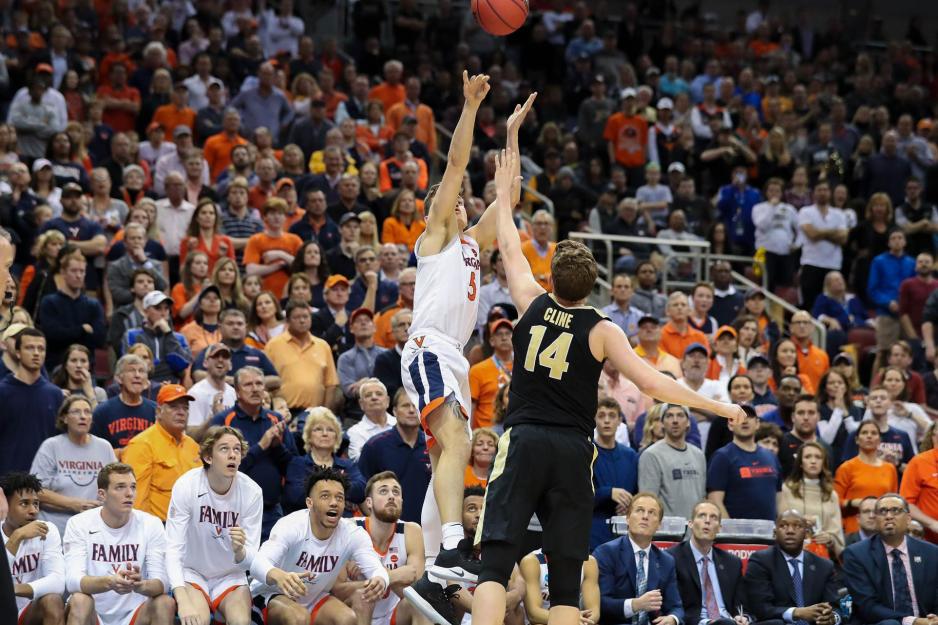 Kyle Guy shoots a basketball over an opponent