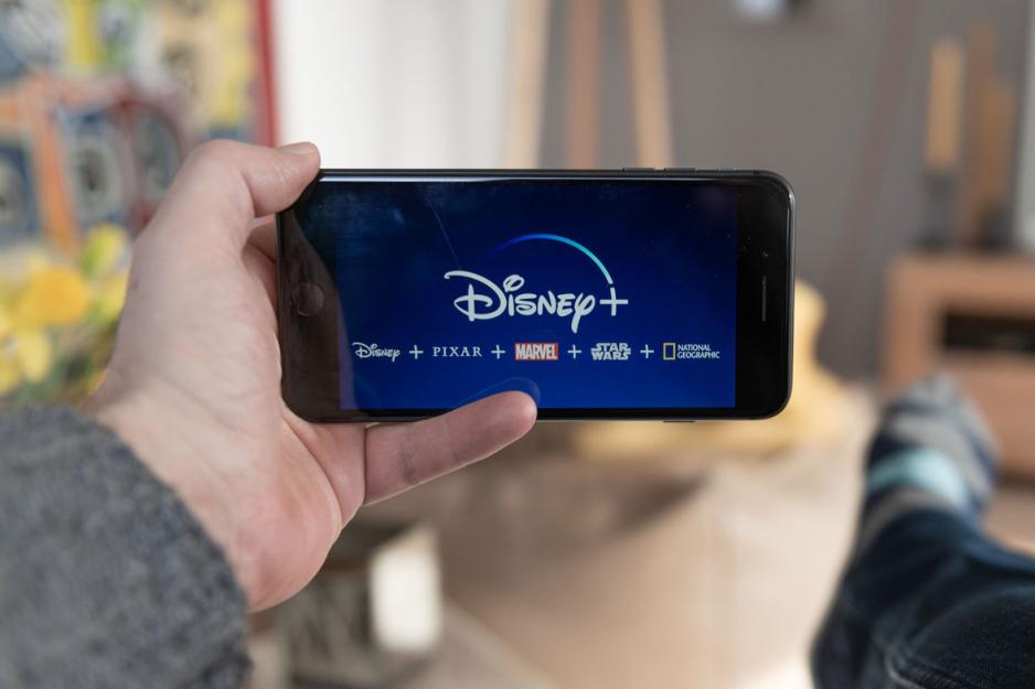 Person holding a phone that had the Disney + logo in the middle and the following horizontal underneath: Disney  + Pixar + Marvel + Star Wars + National Geographic