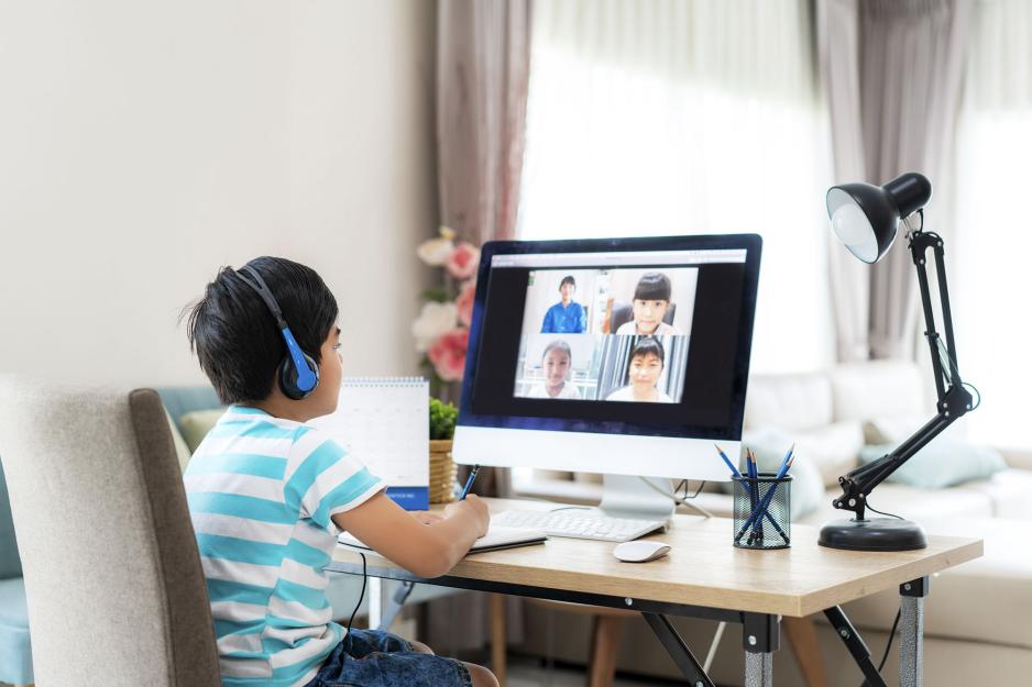 Child sitting at a computer during a zoom meeting for school