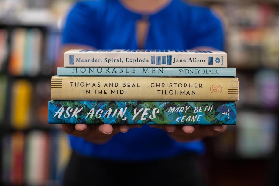 Woman holds four books in her hands