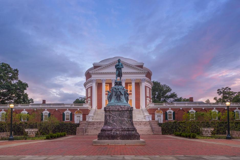 Thomas Jefferson statue in front of the Rotunda with a blue, purple, and pink clouds