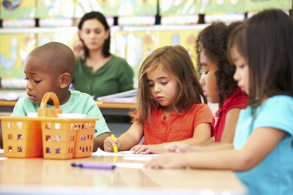 Little Kids sitting at a table coloring