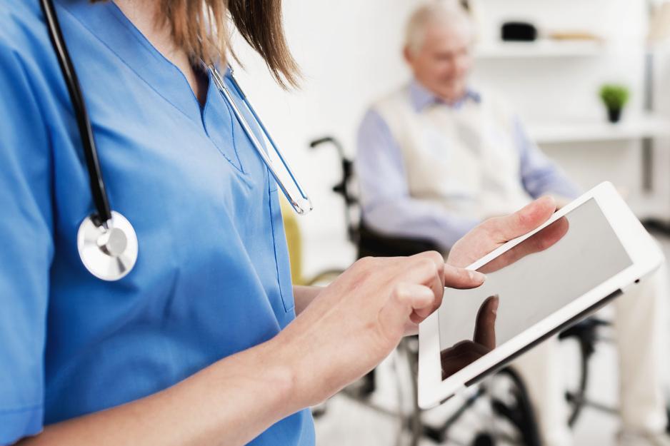 Nurse typing on an ipad