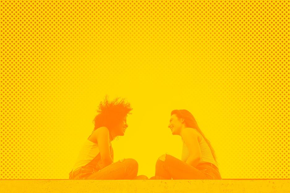two people sitting facing each other talking