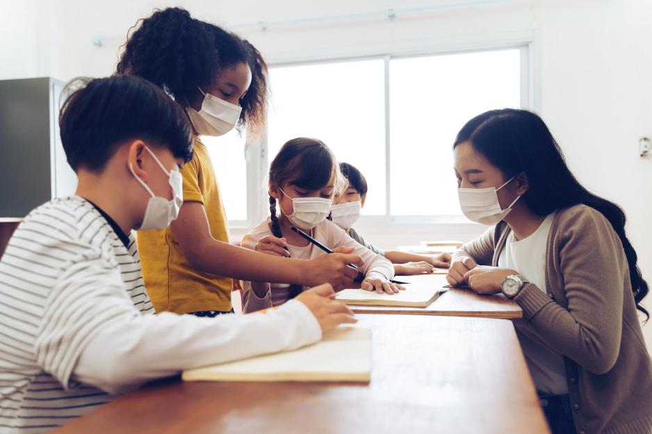 Teacher helping students at a desk