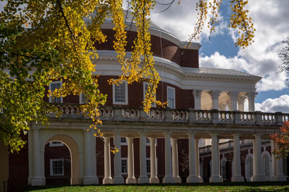 View of the Rotunda from the side with clouds in the sky and yellow and red trees covering portions of the Rotunda