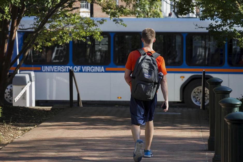 Student walking on the sidewalk to the bus