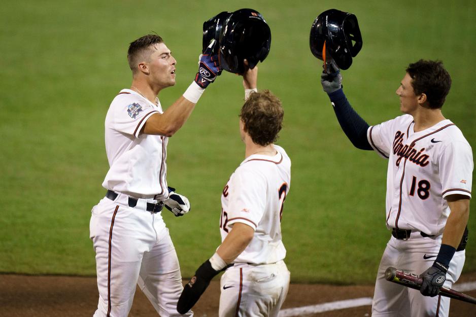 UVA baseball team members tap each others raised helmets 